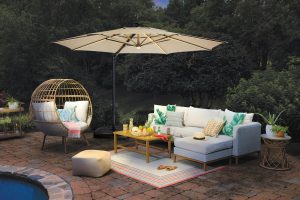 Allen + Roth 11-foot beige slide-tilt cantilever patio umbrella with lights, open over patio seating at night